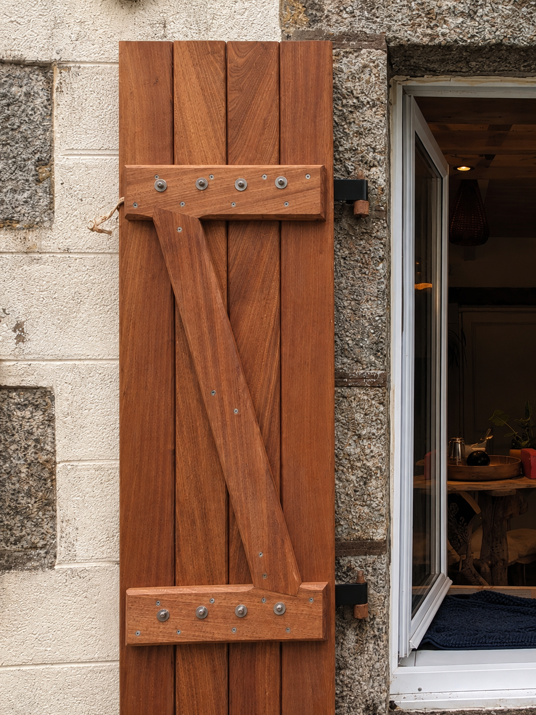 Volet extérieur en bois brun posé sur une façade